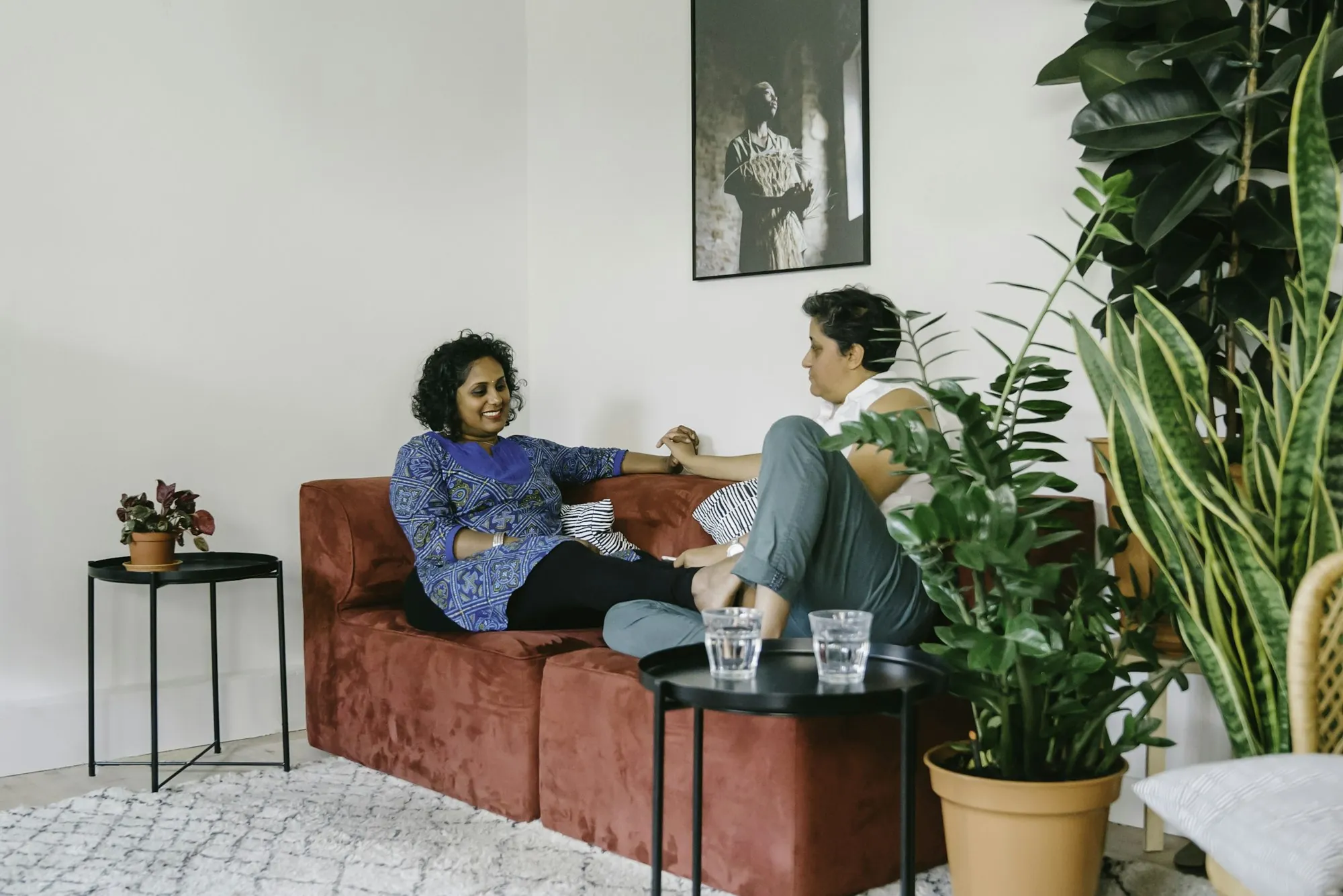 Two women sitting and talking on a sofa